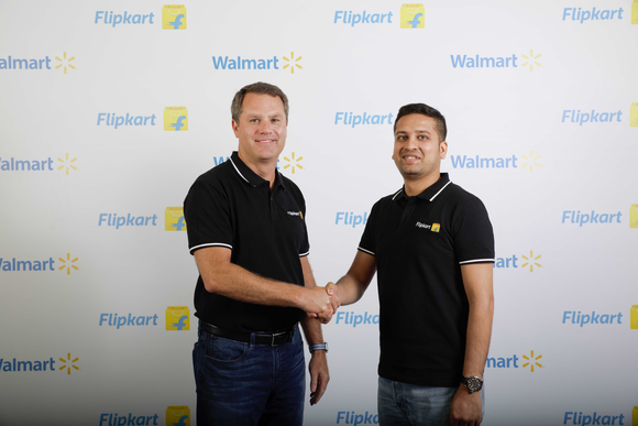 Walmart CEO Doug McMillon and Flipkart co-founder Binny Bansal shaking hands.
