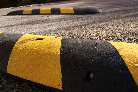 Close-up shot of a black and yellow speed bump with another one in the background.