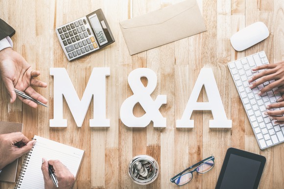 Mergers and acquisitions concept: M and A letters with business items.