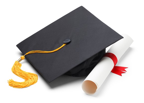 Graduation cap with rolled-up piece of paper next to it