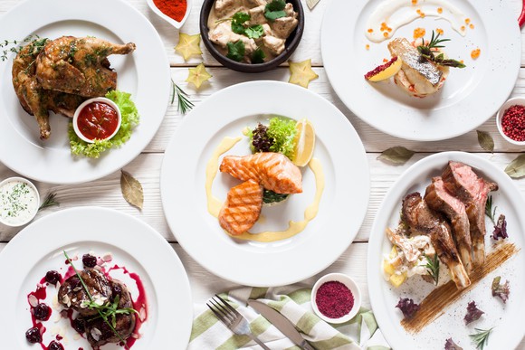 Various food dishes on white plates.