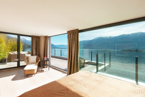Hotel suite overlooking clear mountain lake.