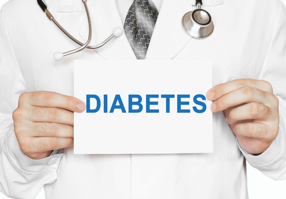 Physician holding card with "diabetes" written on it