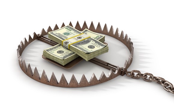 Two neat stacks of cash sitting in a bear trap.