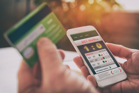Person betting on sports on mobile phone.