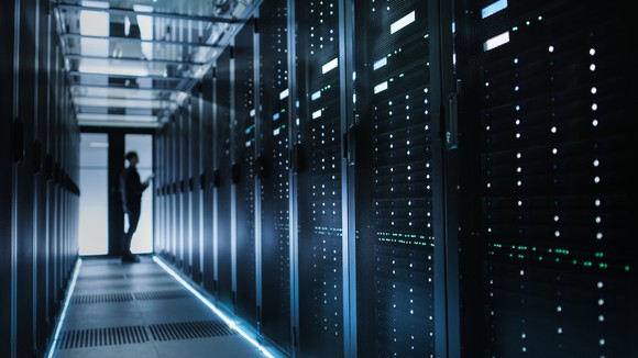 IT employee working in a large data center filled with servers