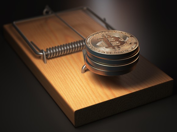 Physical gold bitcoins in a mouse trap.