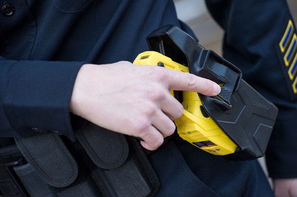 A taser being removed from its holster.