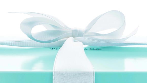 Light blue gift box with white ribbon, with Tiffany & Co. logo partially visible under the bow.