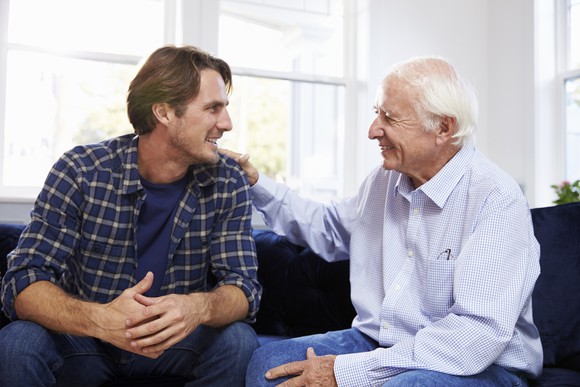 Older man patting younger man on the shoulder