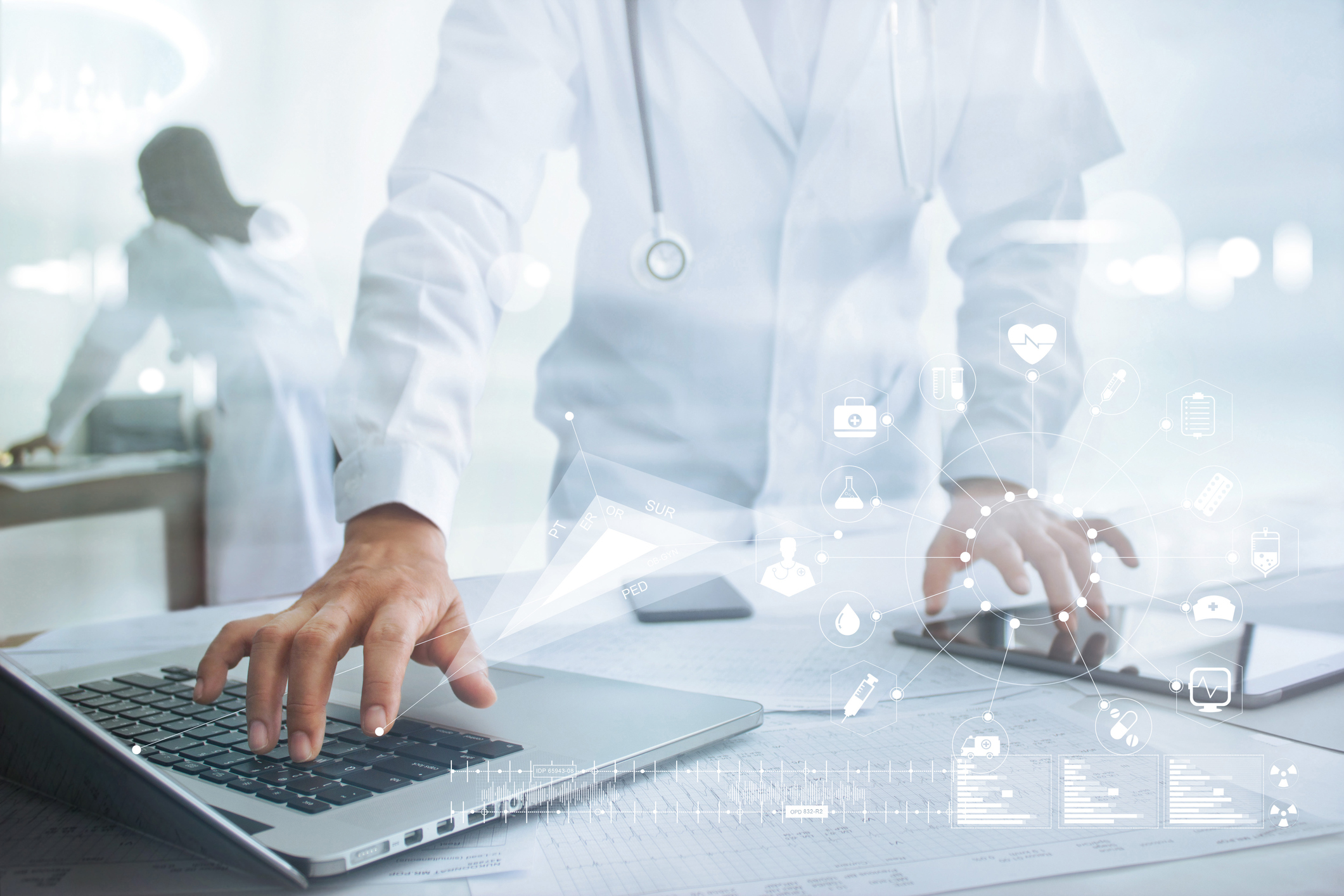 Doctor using computer and tablet.