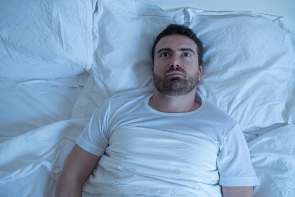 Worried looking person unable to sleep.