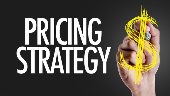a hand writing the words pricing strategy on a screen