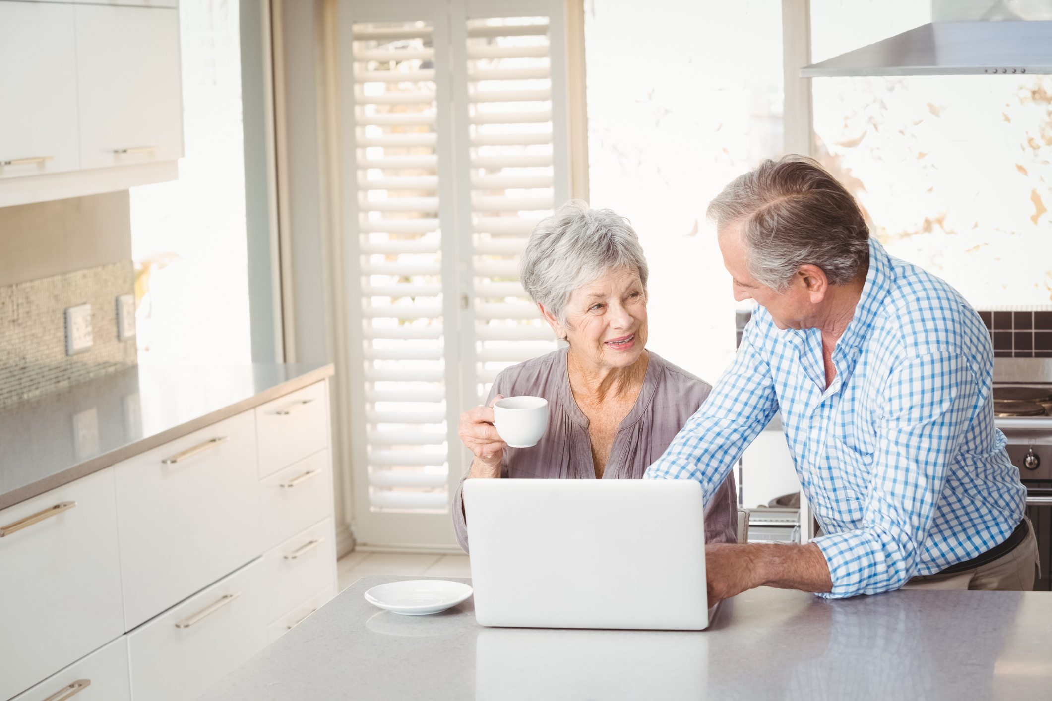 Senior couple at a laptop on a kitchen counter