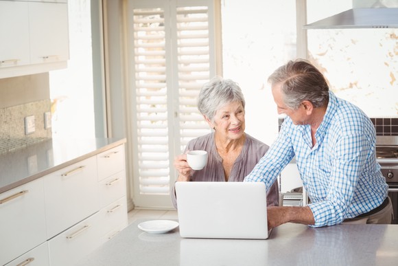 Senior couple at a laptop on a kitchen counter
