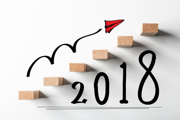 Ascending wooden blocks with a line drawn above them pointed upwards and 2018 written below them