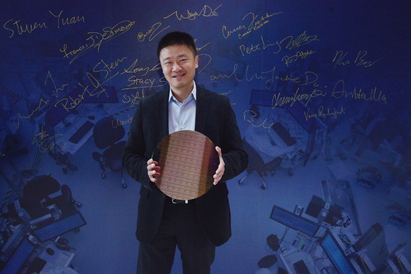 An Arm executive holding an Intel wafer.