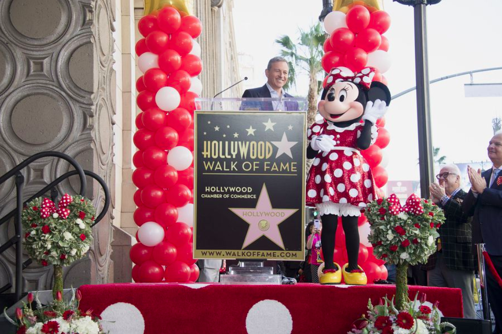 Disney CEO Bob Iger and Minnie Mouse stand on stage to accept a Hollywood Walk of Fame star