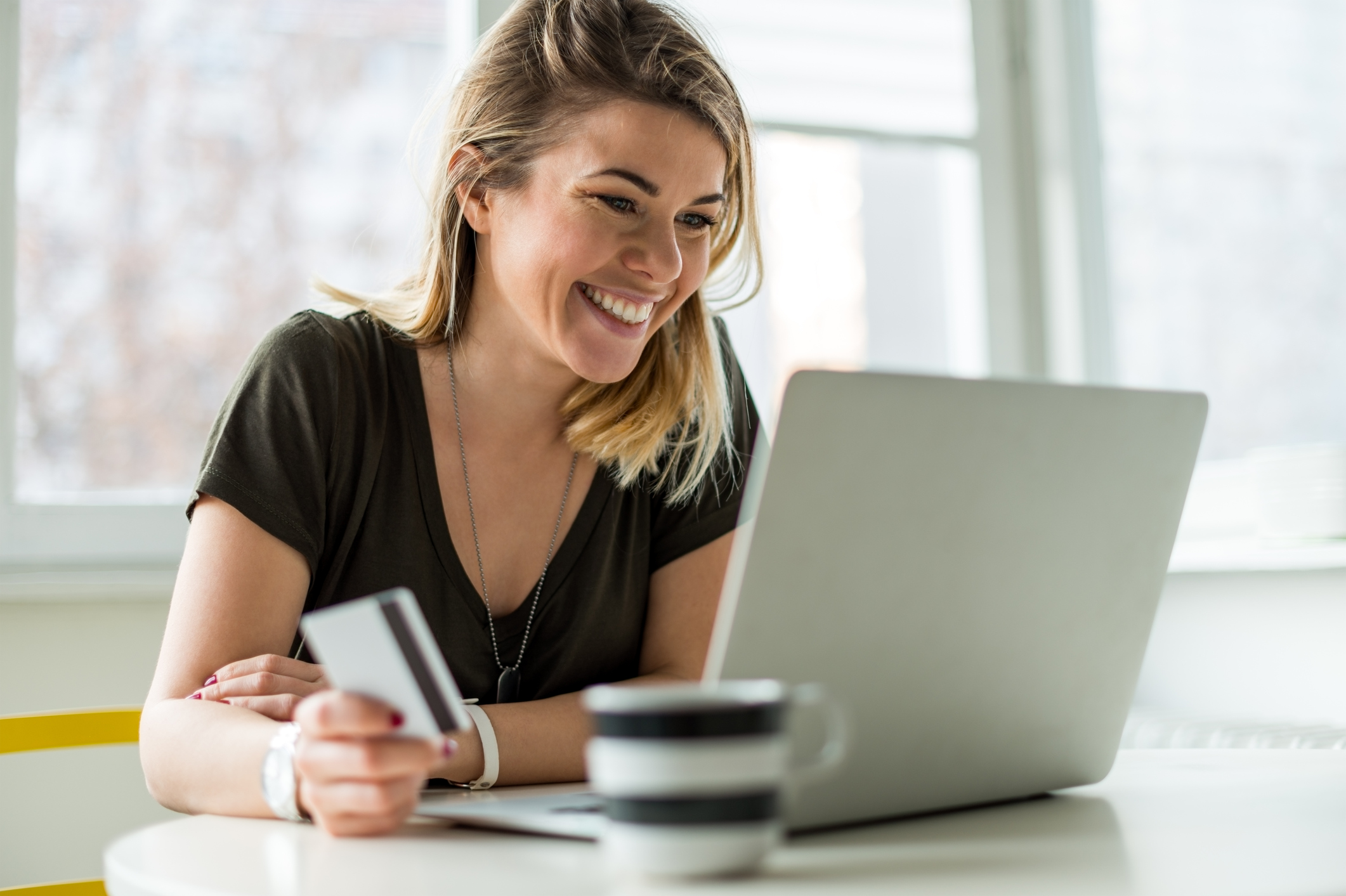 Woman at a laptop holding a credit card