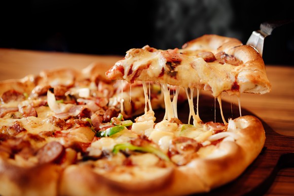 A slice of pizza being lifted from the pie