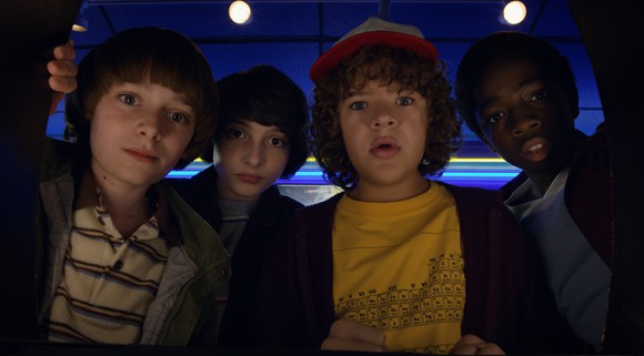 "Stranger Things 2" characters Will, Mike, Dustin, and Lucas looking into the camera.