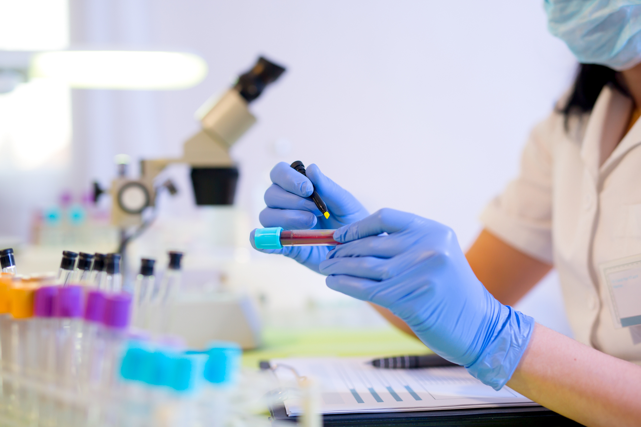 Woman working in a laboratory, writing with a felt pen
