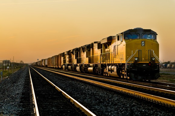 A freight train next to two empty railroad tracks