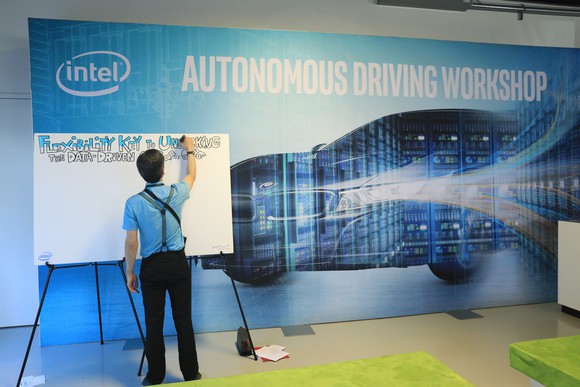 A person writing on a whiteboard at Intel's Autonomous Driving Workshop.