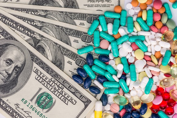 Colorful pills on top of cash money.