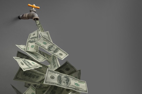 water spigot with U.S. currency flowing out of it