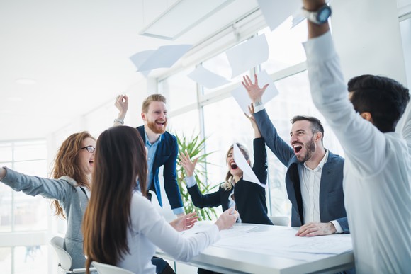 Several business people celebrate good news together.