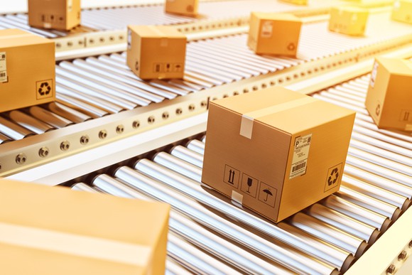 Cardboard boxes taped shut and moving down a conveyor.