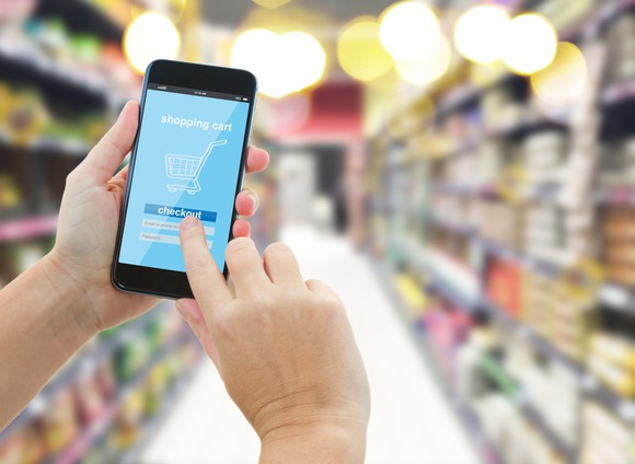 A person holds up a phone in a store.