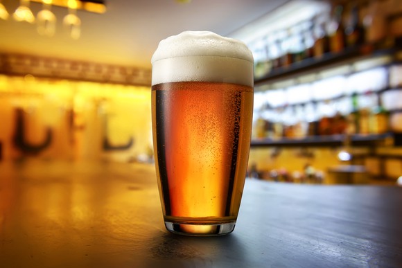 Single beer glass on a bar.