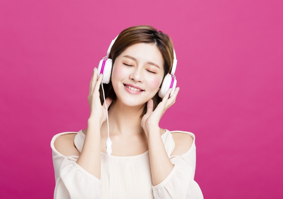 A young woman listens to music.