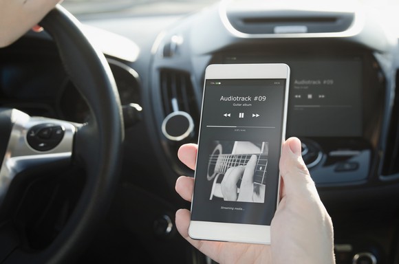 A man listens to streaming music in a car.
