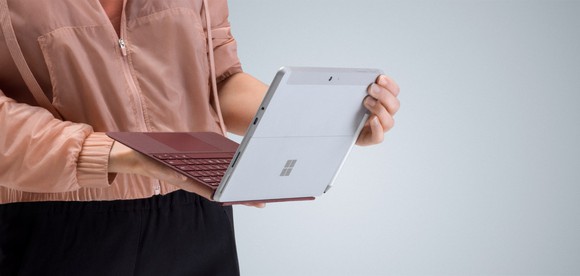 A person holding a Surface Go Tablet.