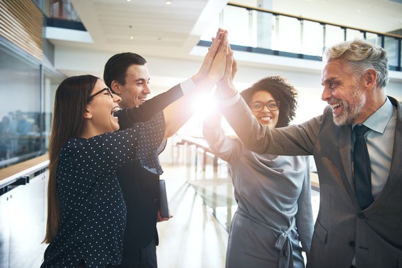 Two women and two men high-fiving each other