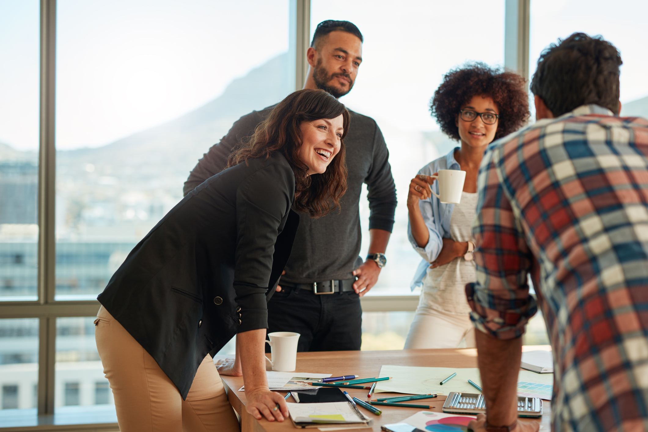 Group of young adults around a table full of office supplies