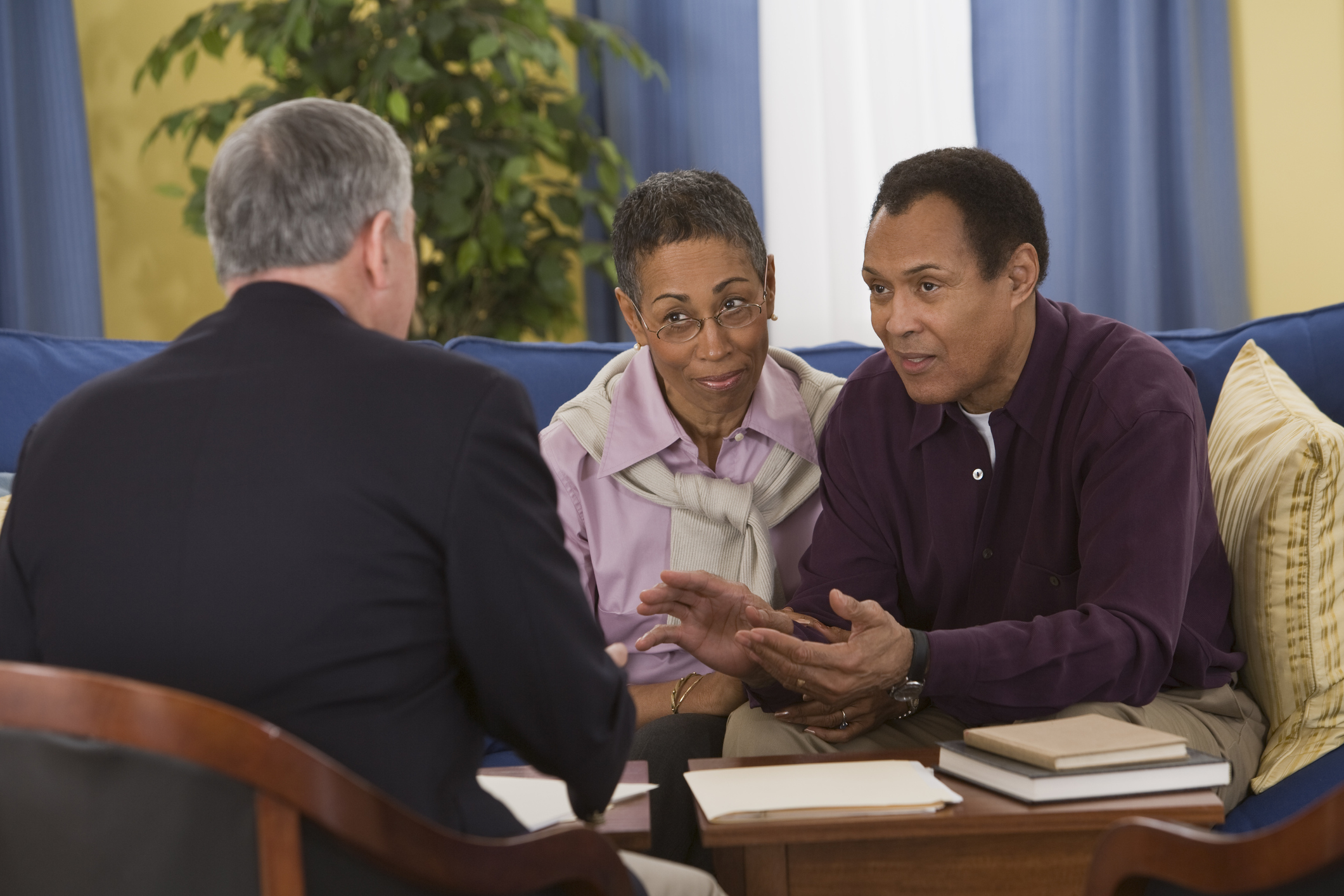 Middle-aged couple sitting across from man in suit