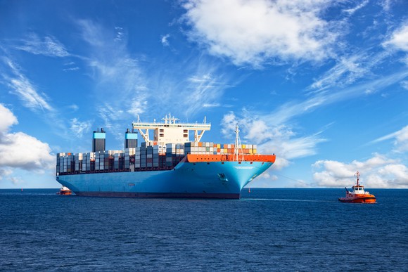 A tug boat pulling a containership.