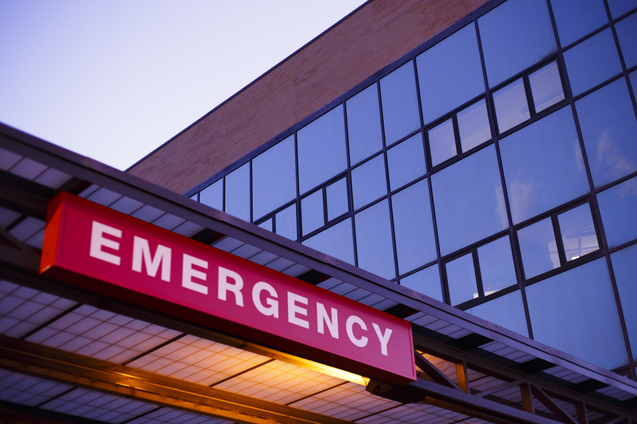 The word Emergency on a red sign over a hospital emergency entrance.