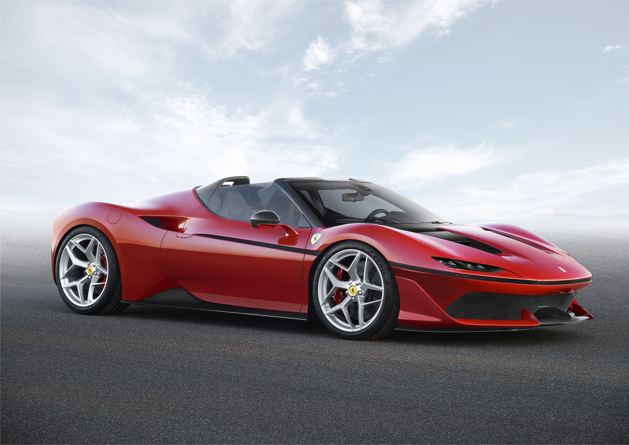 A red Ferrari J50, a mid-engined, two-seat sports car with an open roof and unique styling