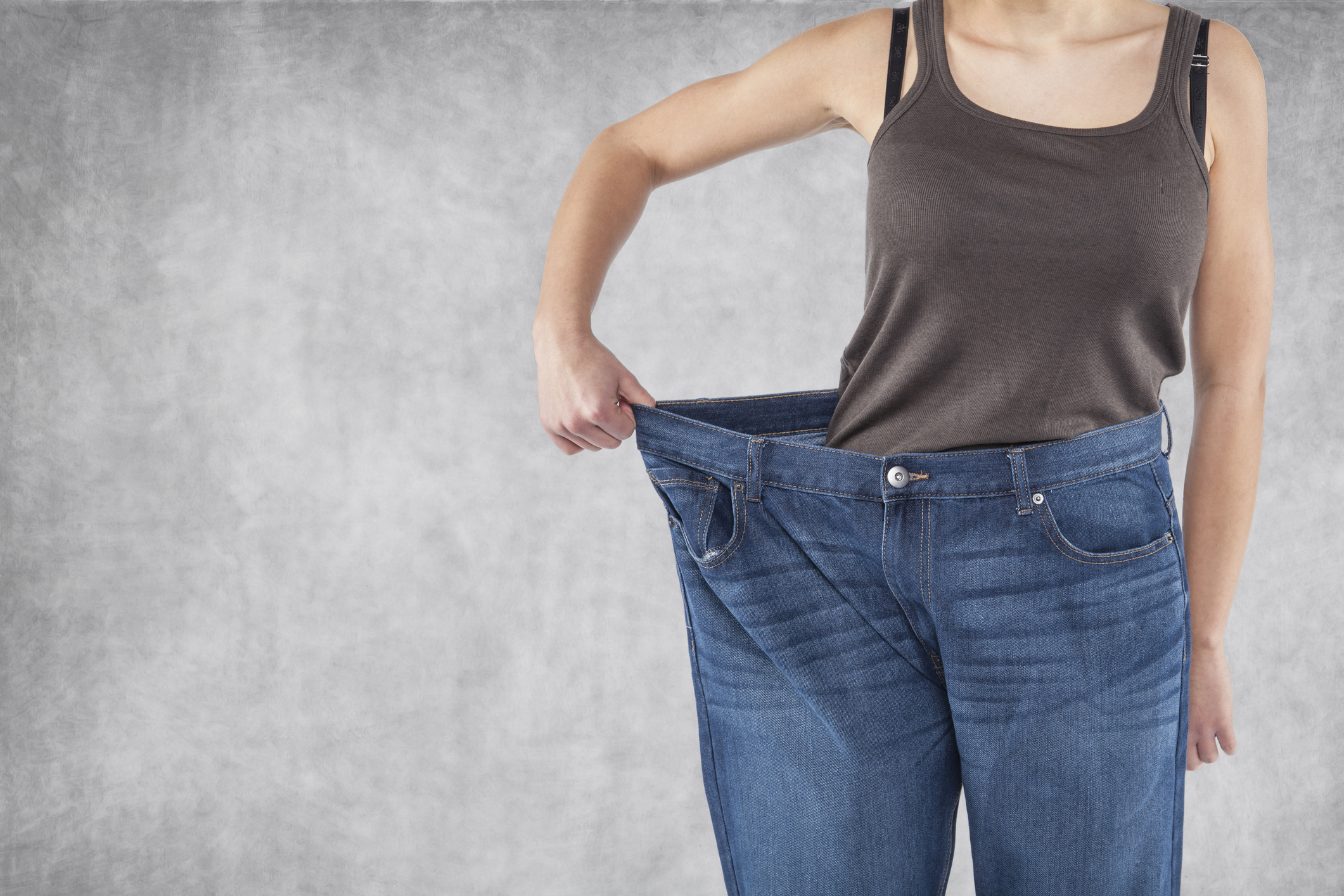 Person wearing oversized pants after losing weight
