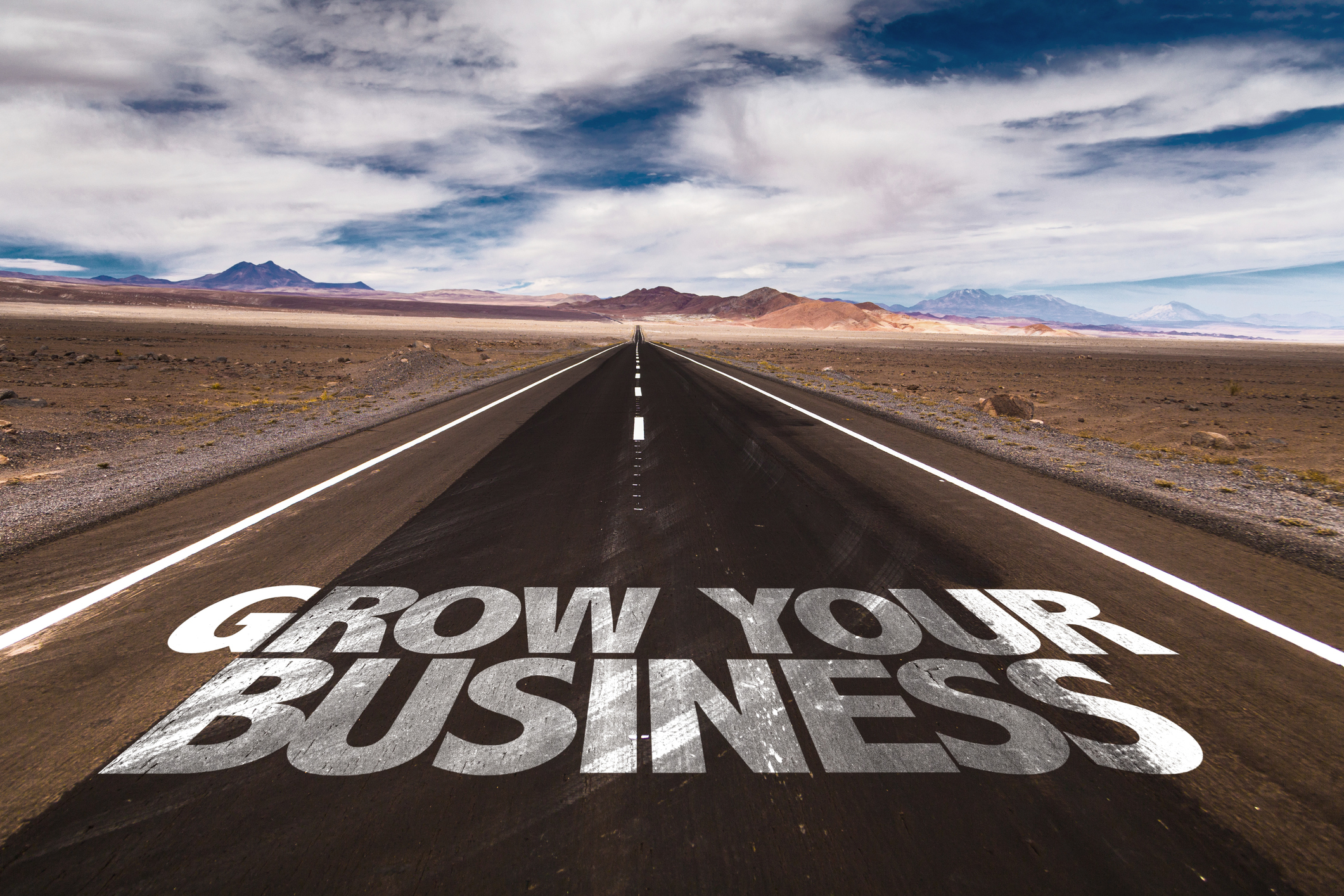 The words grow your business written on an open road
