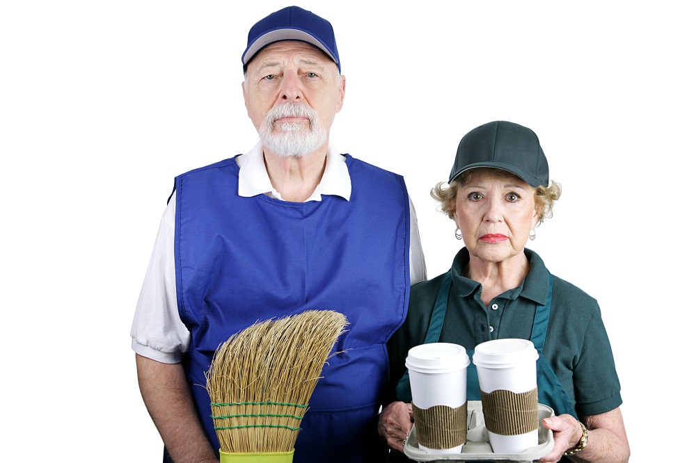 Two seniors wearing work clothes with unhappy expressions.