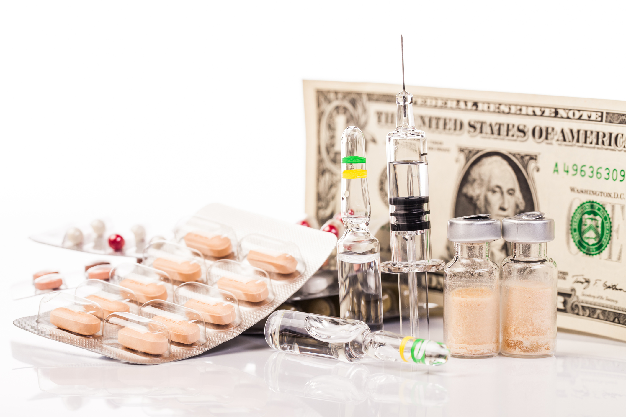 Pills, syringe, vaccine bottles, and a dollar bill.