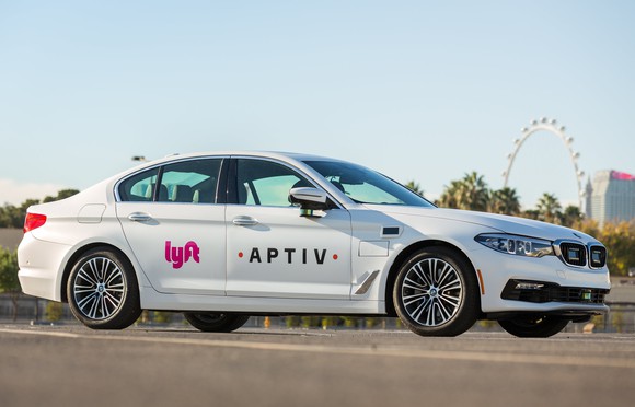 A white BMW sedan with visible (but subtle) self-driving sensors and Lyft and Aptiv logos on its doors.