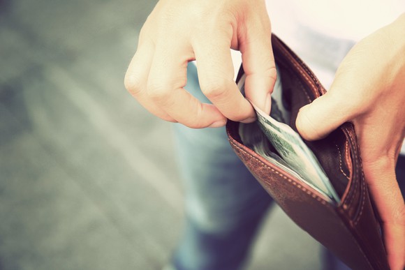 Person taking cash from a wallet.