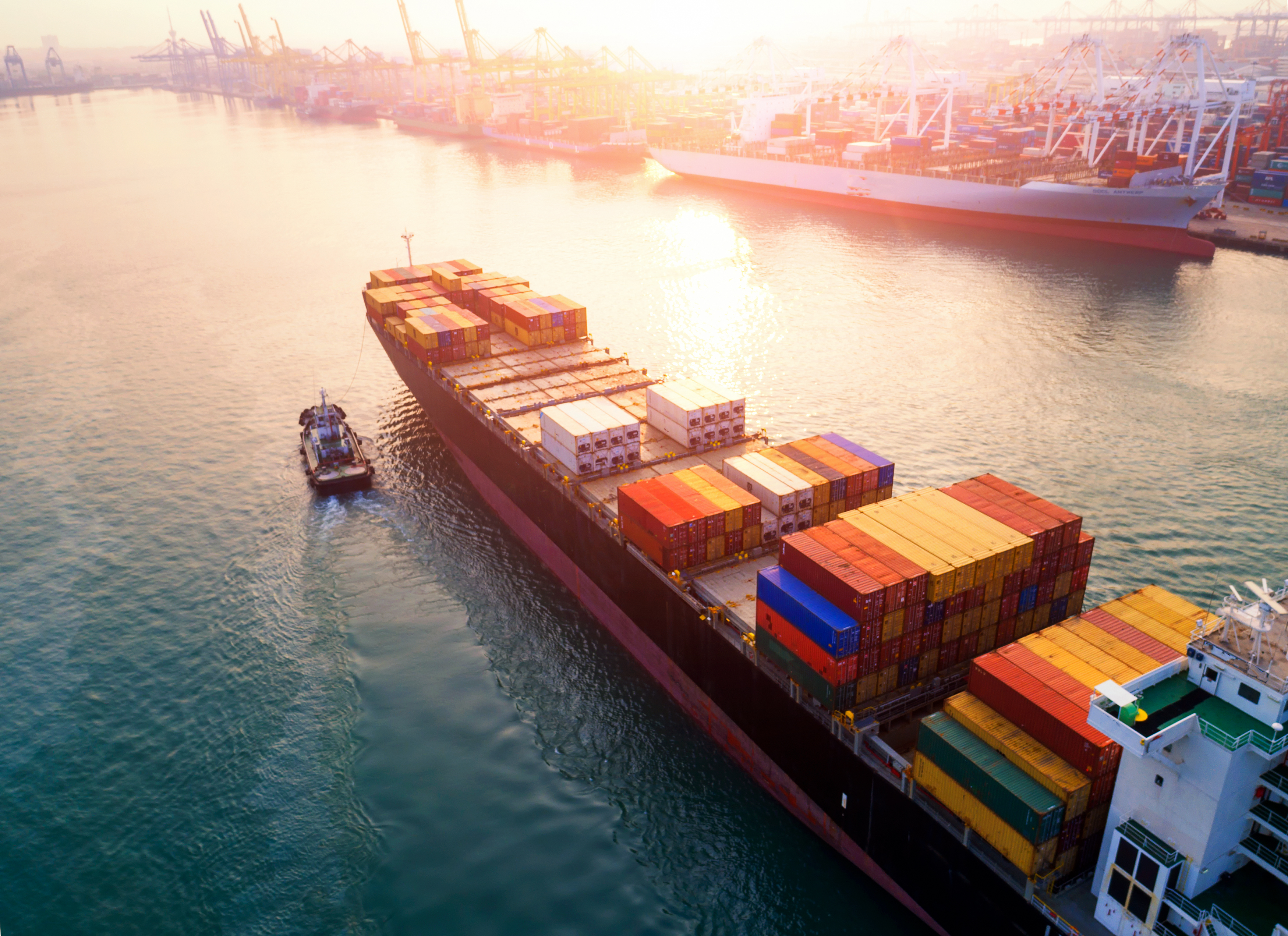 A shipping vessel carrying shipping containers away from a port.